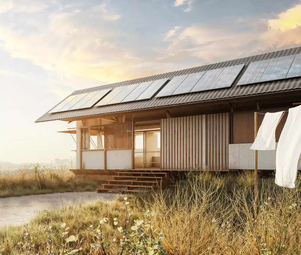 Eco houses design with modern rural home and rooftop solar panels in dry grass landscape