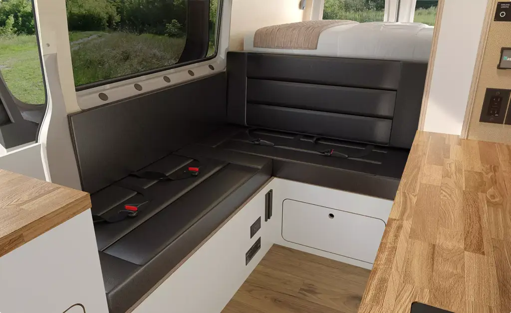 campervan interior design bench seating with seatbelts, raised rear bed and storage compartment below