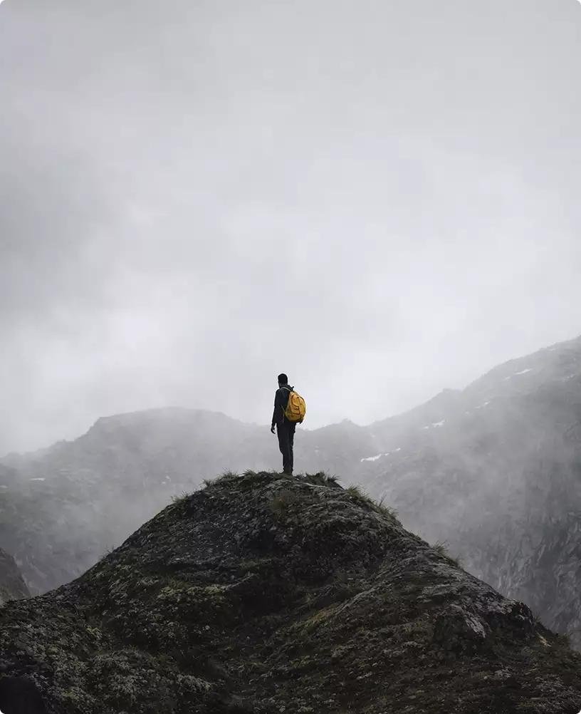 campervan interior ideas inspiration from lone hiker standing on rocky mountain ridge in foggy landscape