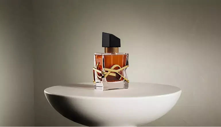 3D cosmetic perfume bottle centered on round pedestal with soft shadows in minimal setting
