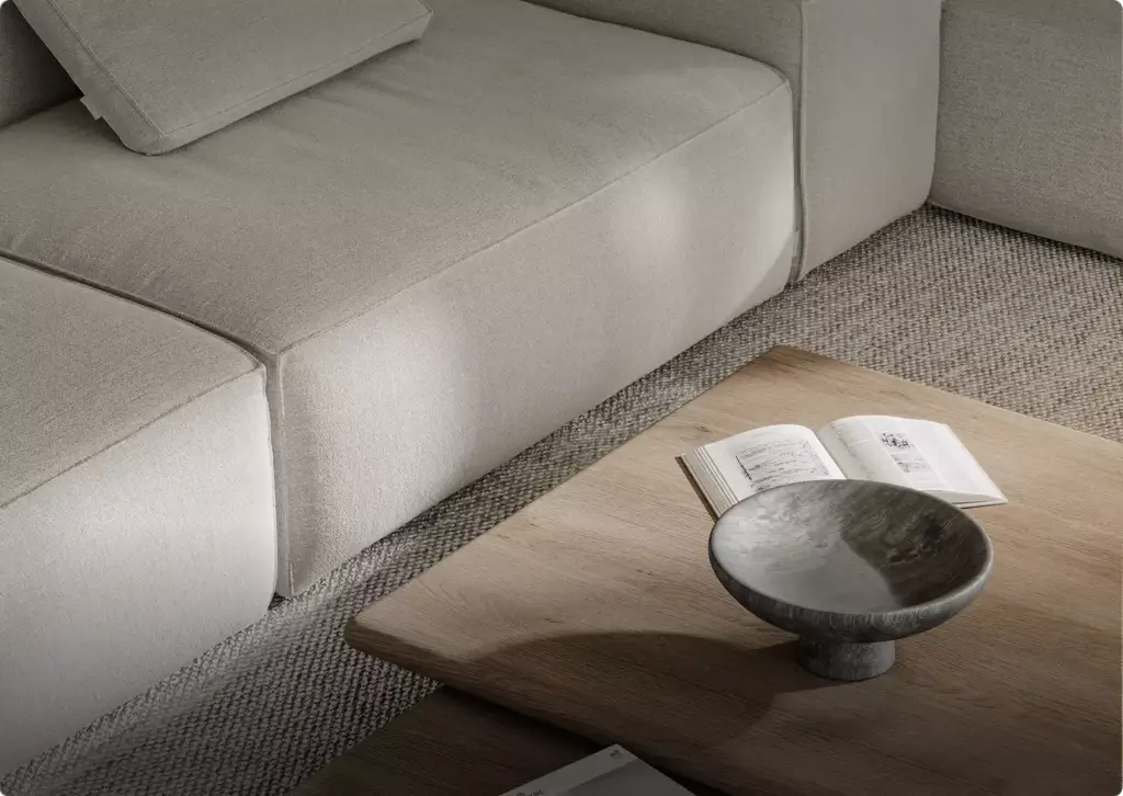 Close view of fabric sofa and wooden coffee table with book and bowl, textured rug, 3D furniture rendering
