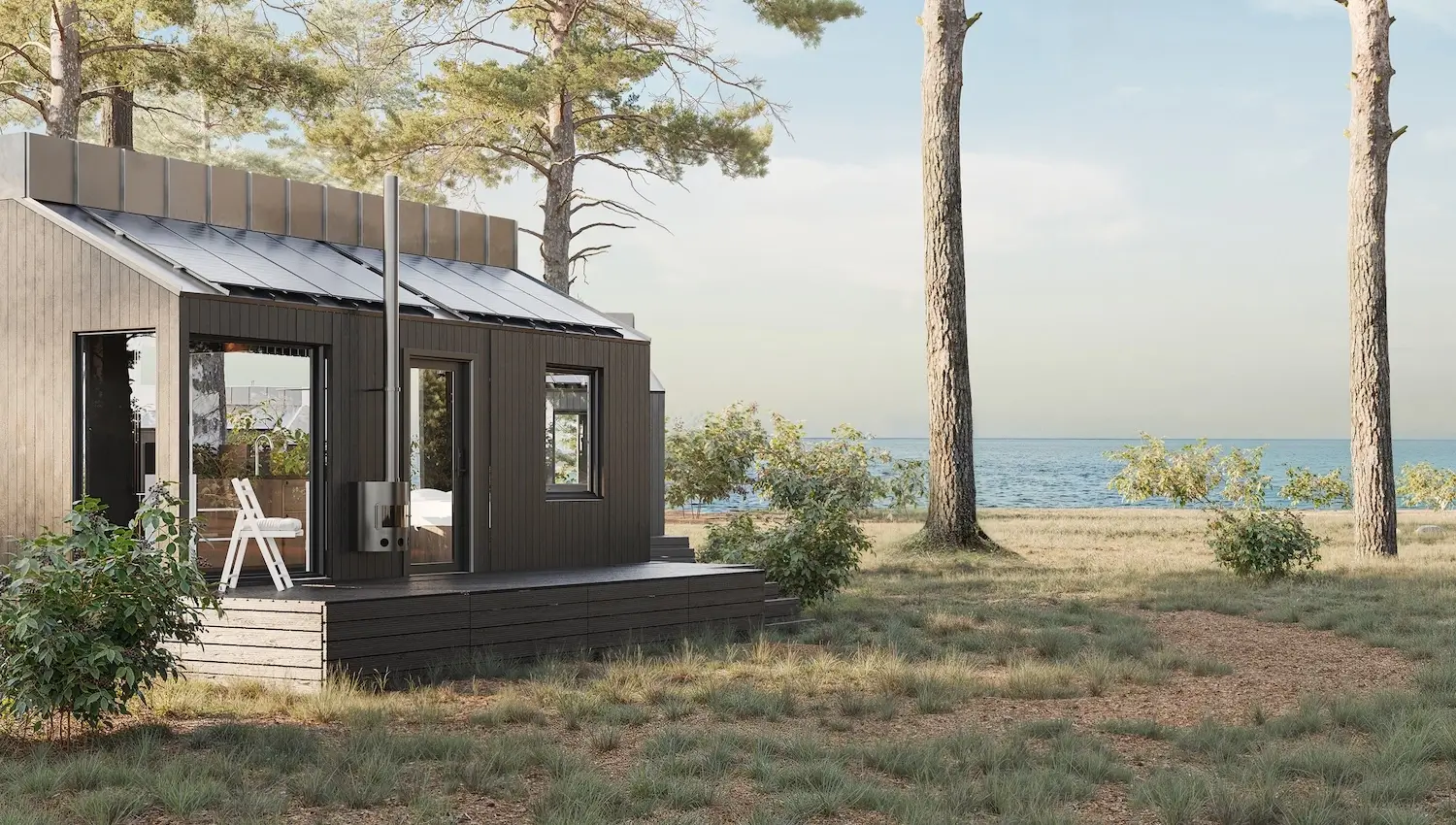 What Is Modular Housing? A Clear Definition and How It Works Modern modular home by the water with solar panels and dark wood exterior