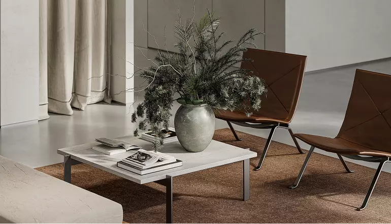 Clothing store 3D rendering with coffee table, books, plant vase, and modern seating on textured rug