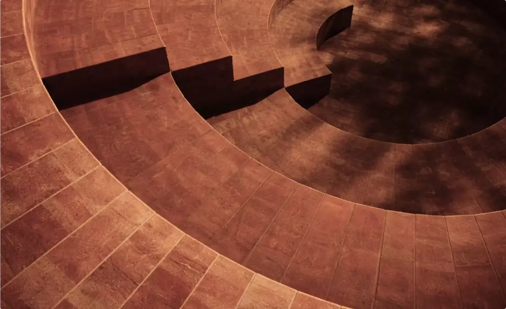 Desert hotel 3D rendering interior courtyard with circular steps and warm light shadows