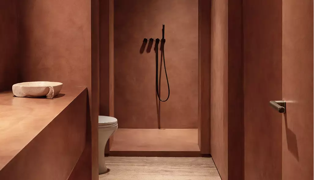 Desert resort visualization bathroom with minimal clay walls shower and sink in warm tones