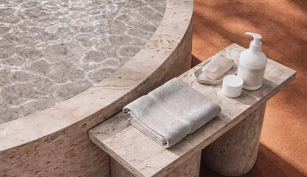 Desert resort visualization spa detail with stone basin water towels and toiletries