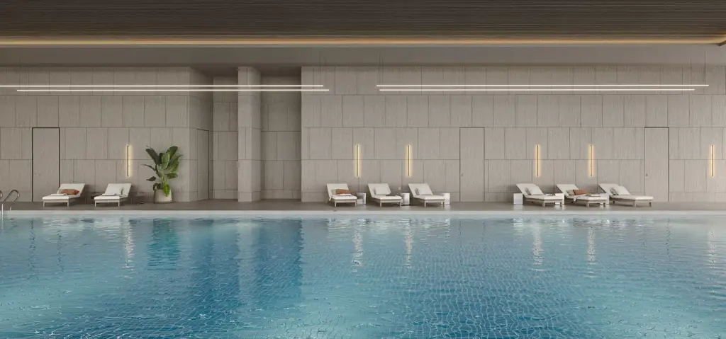 Indoor pool area fitness center interior design with lounge chairs, tiled walls, and calm water surface