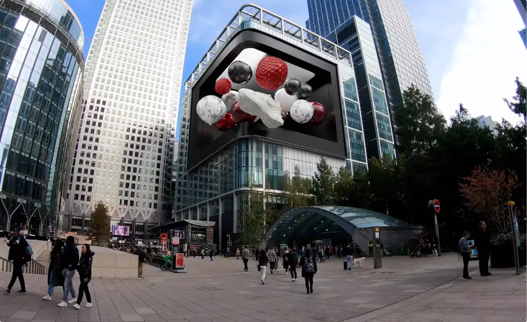 Fooh ads on a giant 3D billboard above a city plaza, with towers, pedestrians, and a station entrance