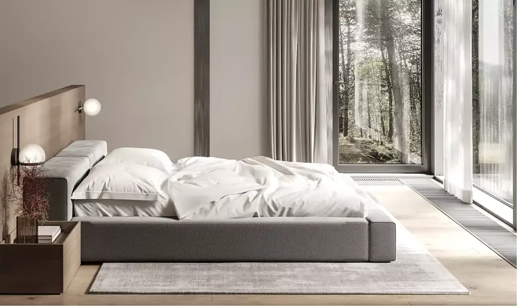 Forest house interior bedroom with low bed, soft bedding, and large window overlooking forest trees