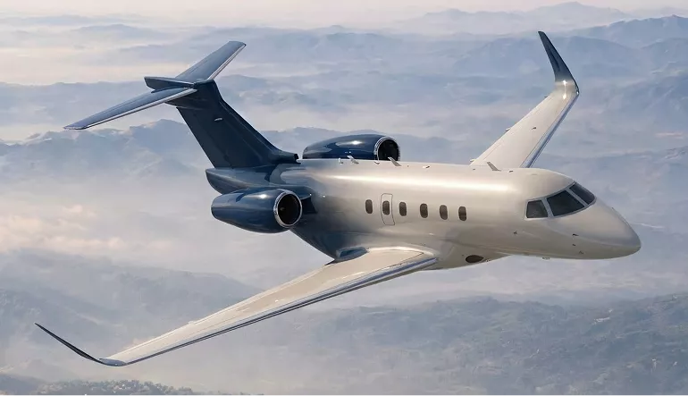 Gulfstream G450 airplane design jet banking over mountains with clouds below and swept wings visible