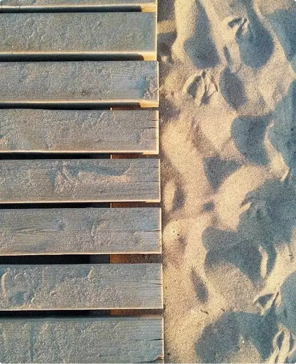 Hotel 3D rendering detail of wooden deck beside sand with footprints and textured surface