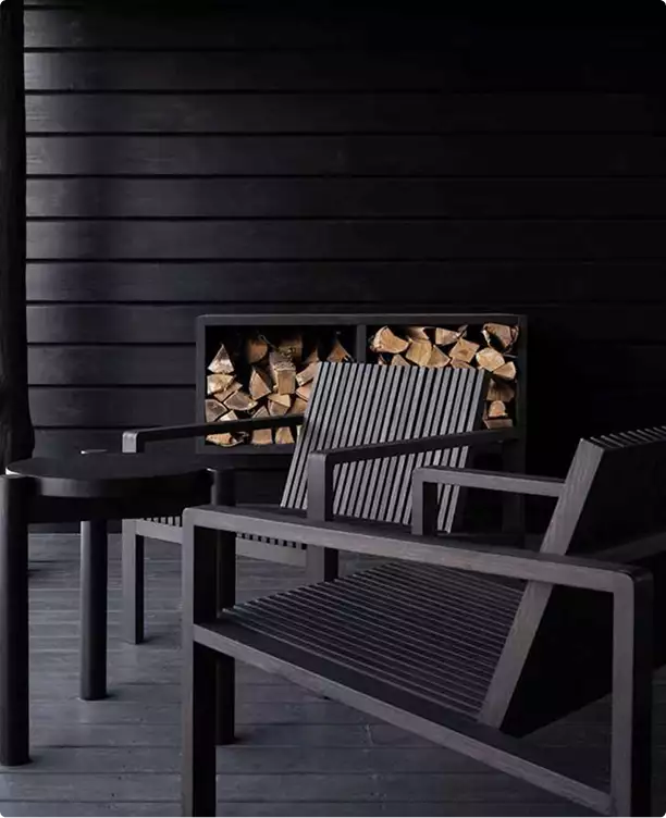 Outdoor seating in private house 3D rendering with black wood walls, chairs and stacked firewood