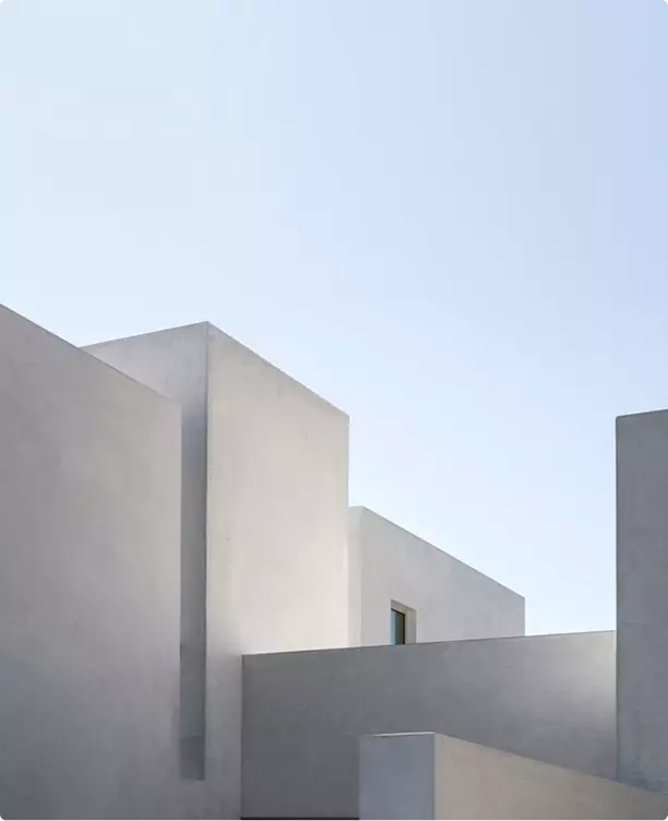 Real estate 3D exterior rendering of minimal white building forms under clear sky