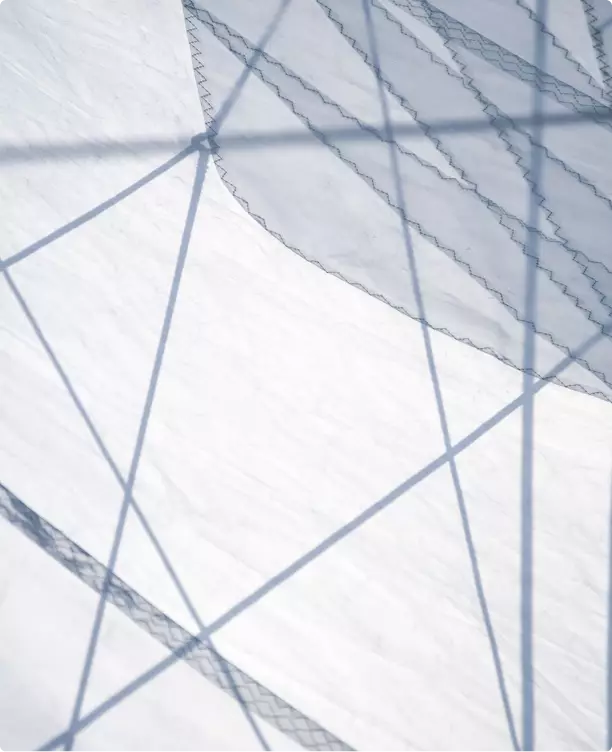 Sailboat visualization close-up of white sail fabric with stitching and rigging shadows crossing surface