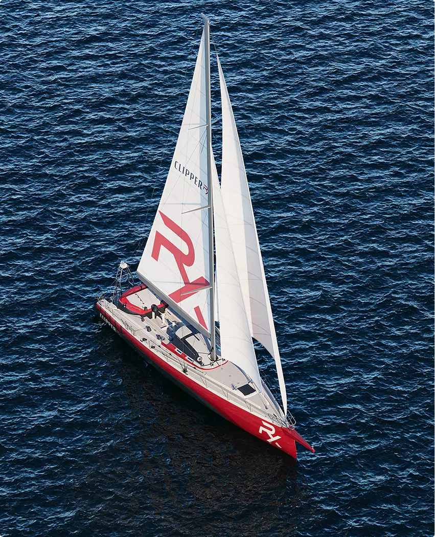 Sailing yacht CGI aerial view of red and white yacht sailing on deep blue ocean surface