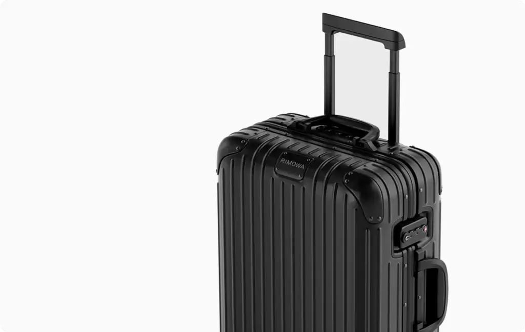 Black ribbed suitcase with extended handle isolated on white background studio packshot