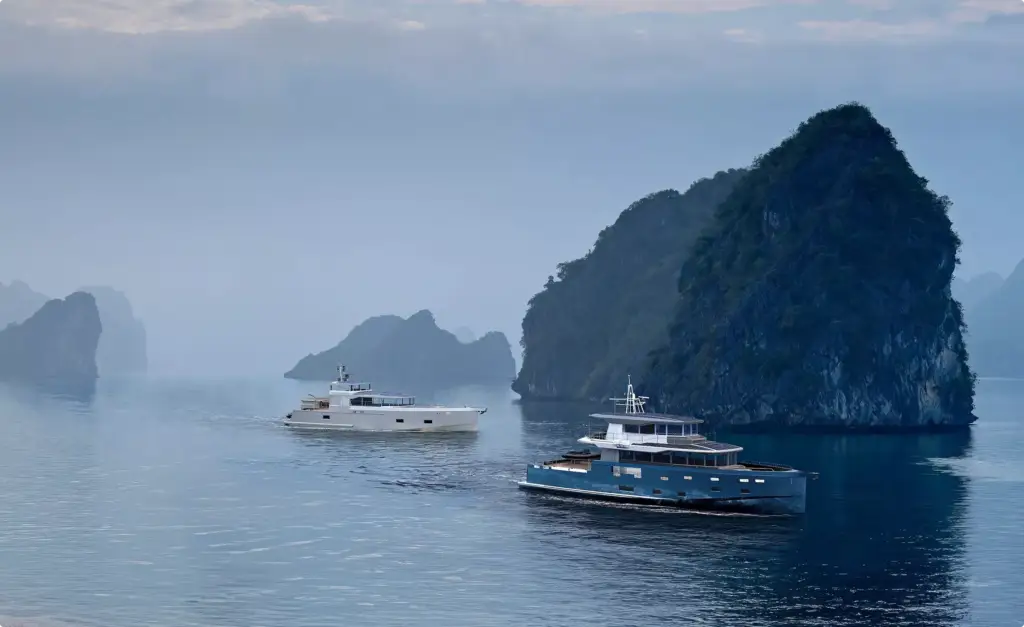 Two luxury yachts in yacht rendering portfolio cruising beside misty limestone islands