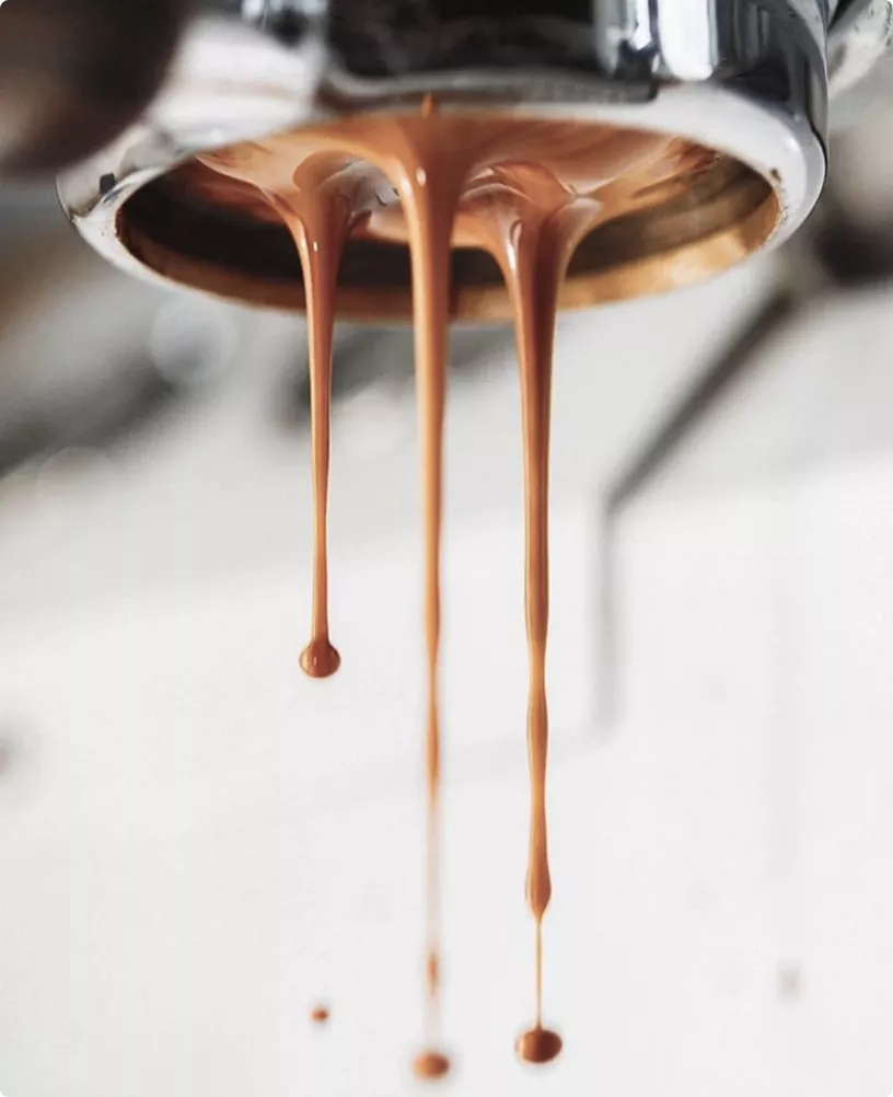Espresso dripping from portafilter in cafe interior CGI with soft blurred background