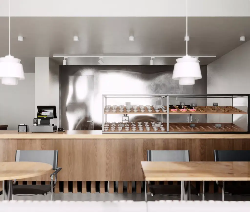 Cafe interior CGI with pastry display counter, wood finishes, and pendant lighting