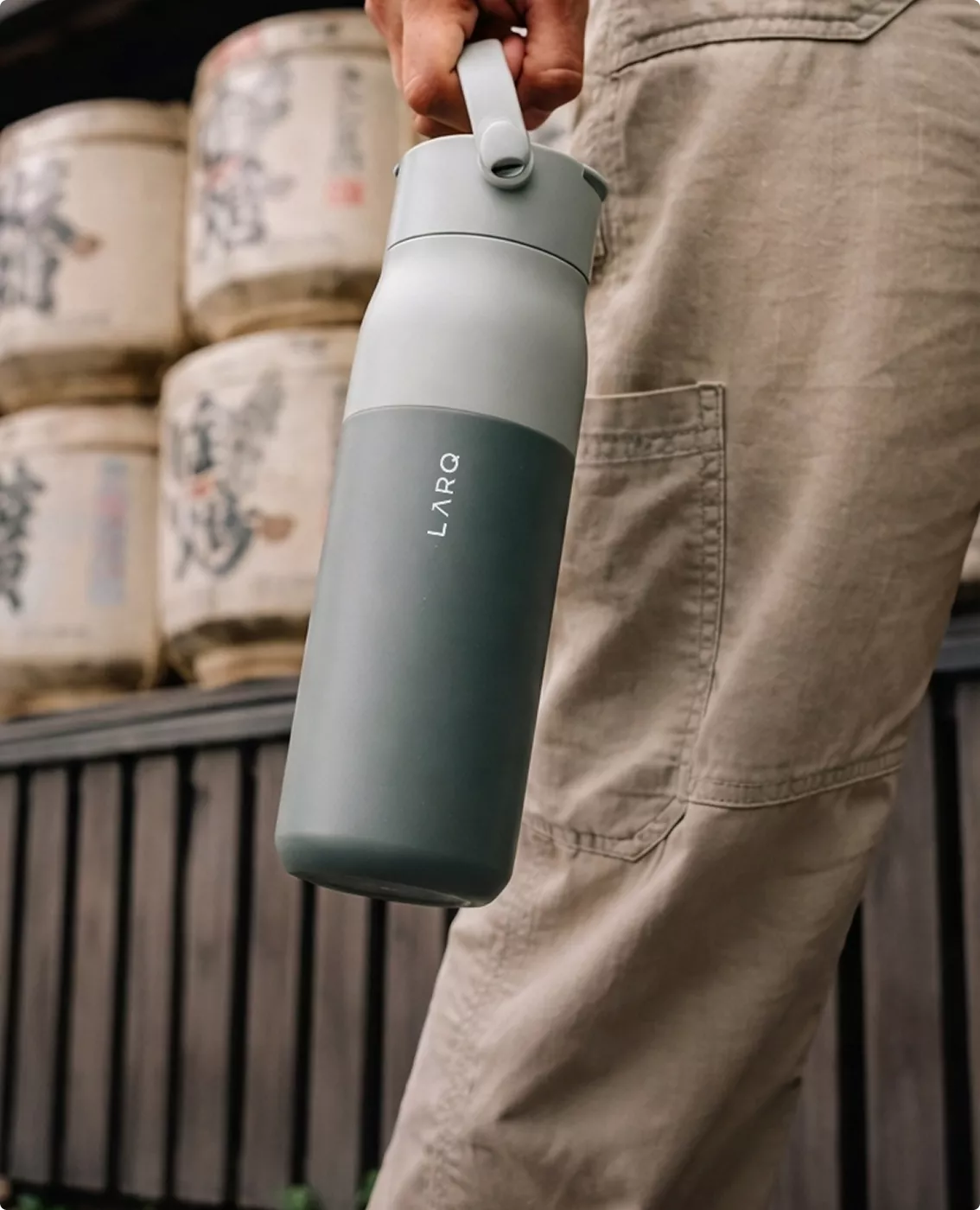 CGI campaign visuals for LARQ bottle carried by hand in urban outdoor lifestyle setting