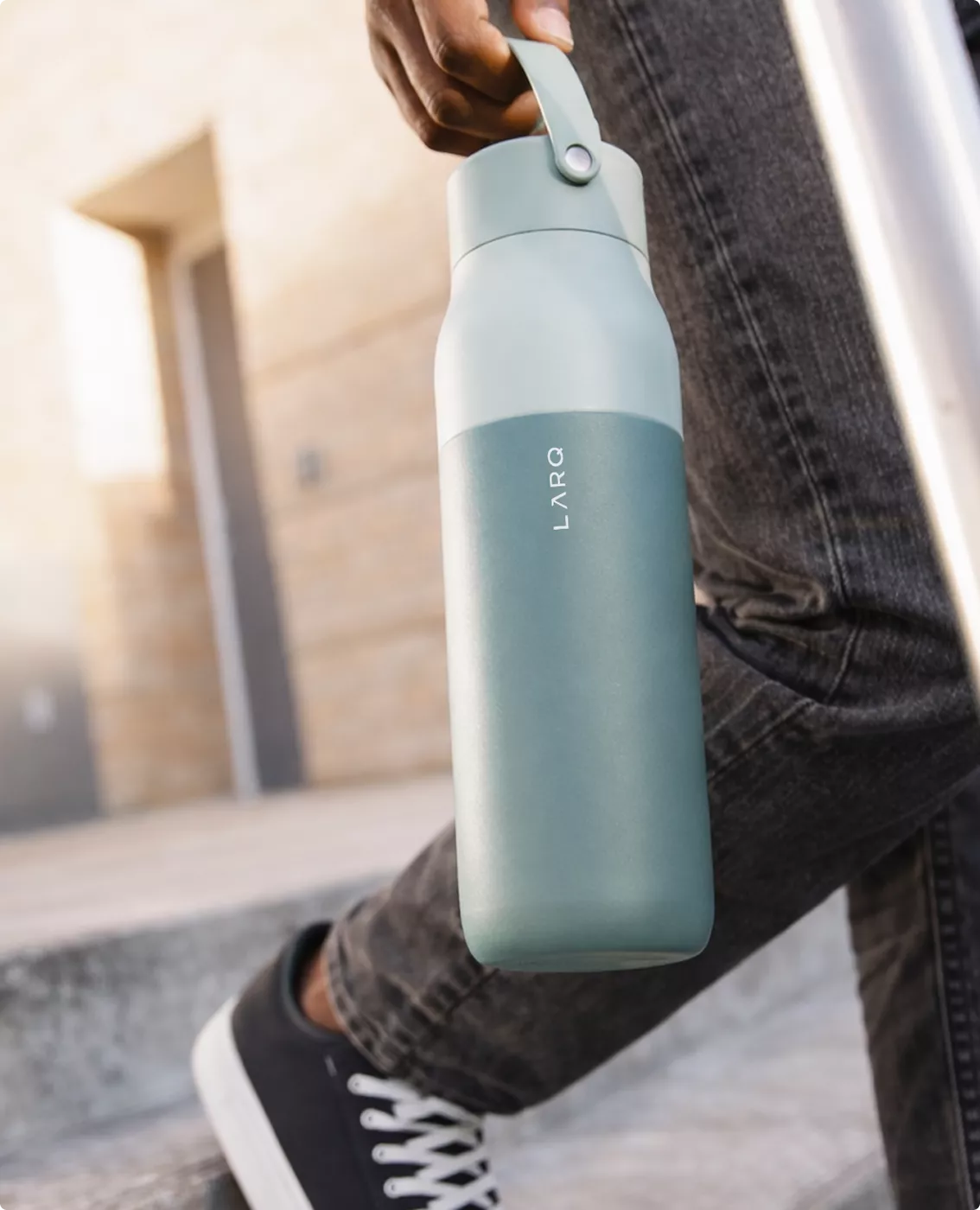 Mint green LARQ bottle visualization carried outdoors by person walking in sneakers