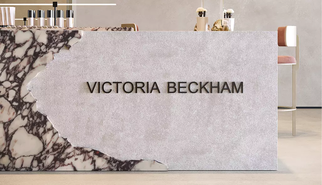 Luxury beauty retail counter with premium stone finishes, elevated brand signage, and refined cosmetic presentation.