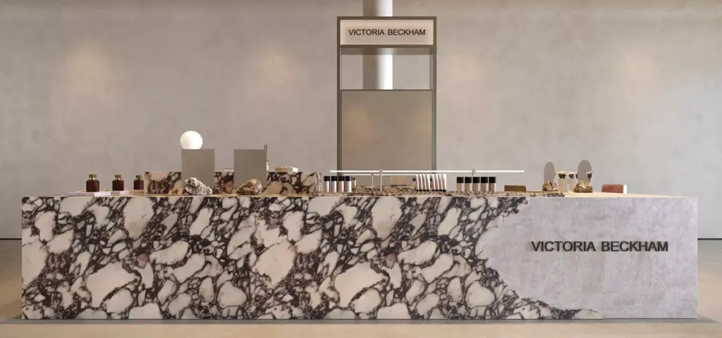Luxury beauty retail cosmetic display island with elegant marble textures, premium branding, and minimalist merchandising setup.