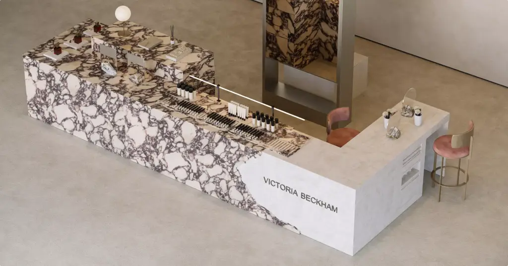 Top perspective view of a luxury beauty retail kiosk featuring marble finishes, organized makeup displays, and refined seating areas.