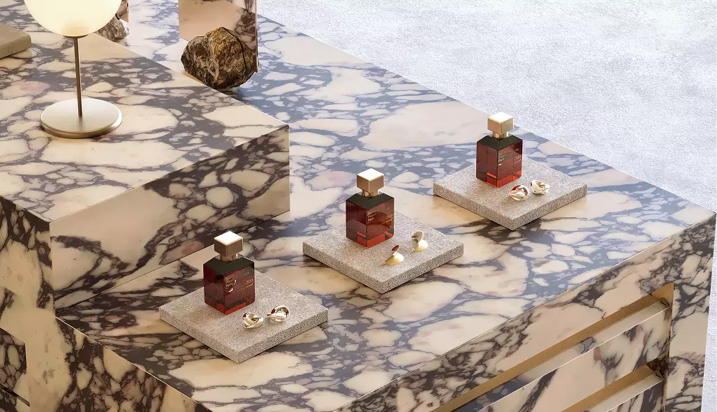 Elegant fragrance display counter in a luxury beauty retail setting featuring marble materials and sophisticated product styling.