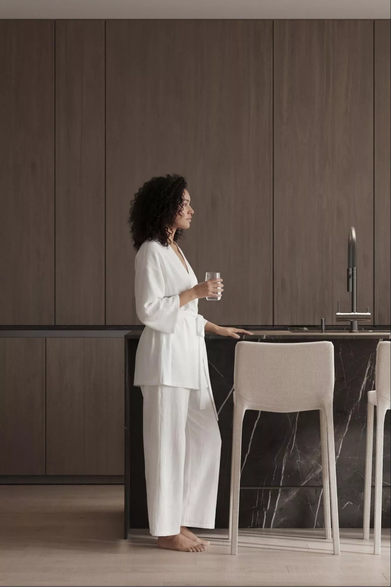 Kitchen Renders: Photorealistic 3D Examples, Techniques, and Agency Guide Photorealistic kitchen render with dark wood cabinets and woman beside black marble island