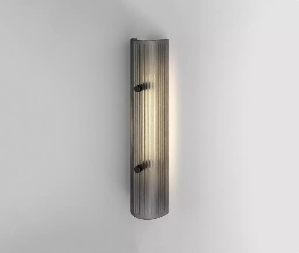 Vertical ribbed glass wall fixture glowing on white wall, wall light visualization.
