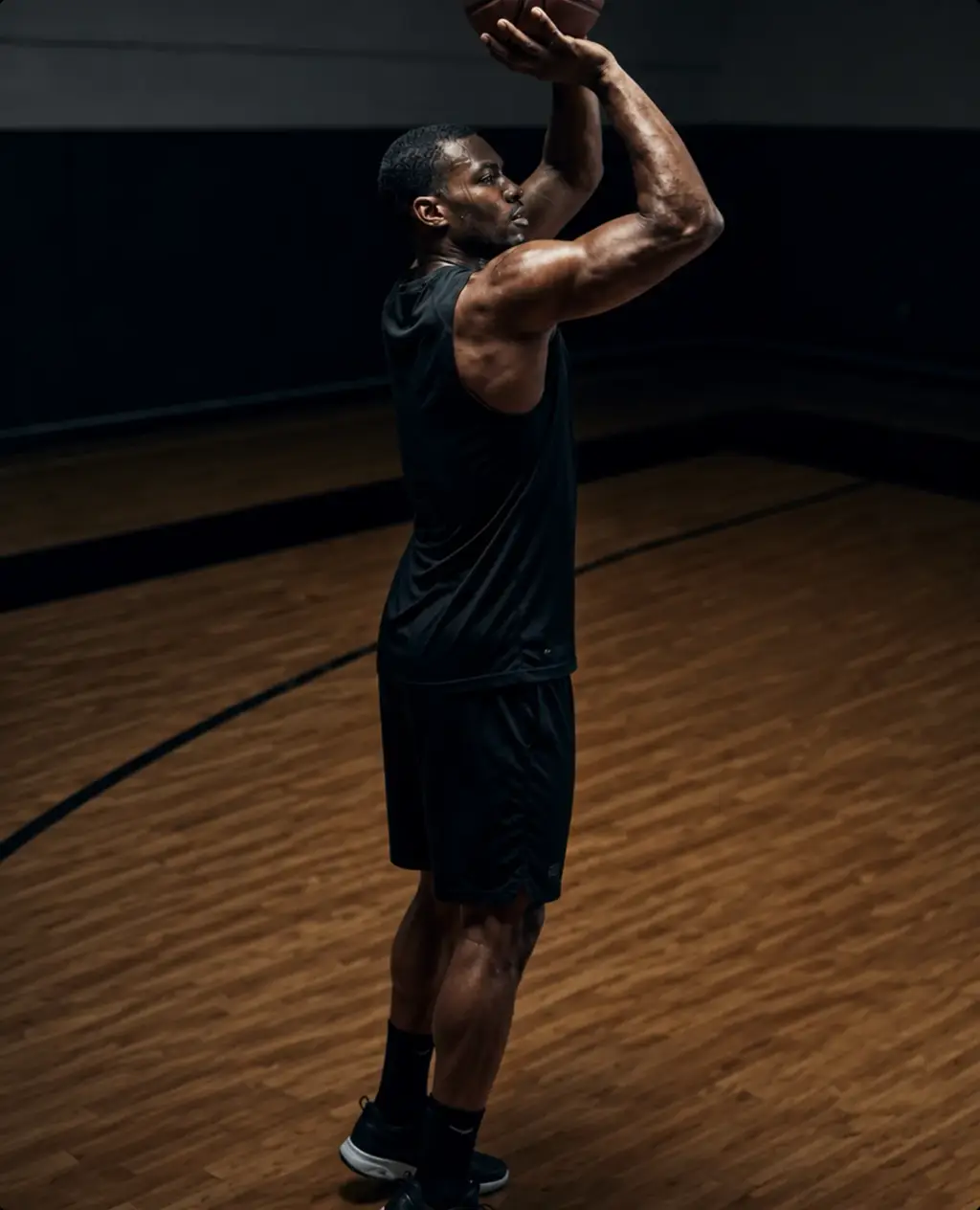 Athlete under a spotlight on a basketball court.