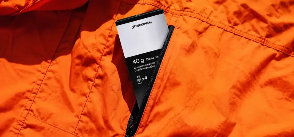 Decathlon energy gel sachet in an orange jacket pocket.