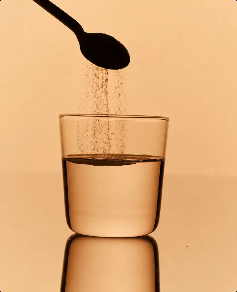 Effervescent electrolyte tablet dissolving in a glass of water.