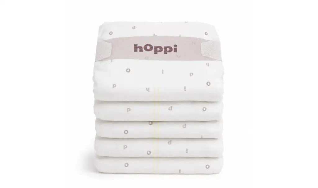 Neat stack of folded hoppi diapers with logo waistband, baby diaper product visualization.