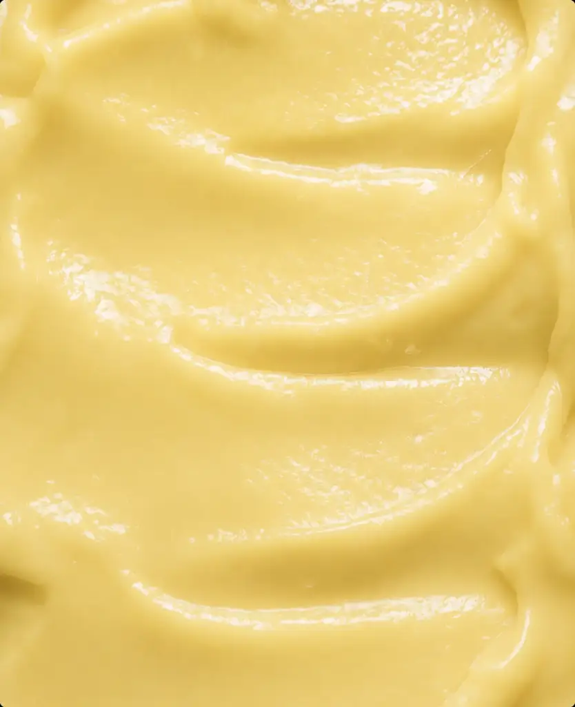 Macro close-up of glossy yellow face cream texture, AI product visualization detail.